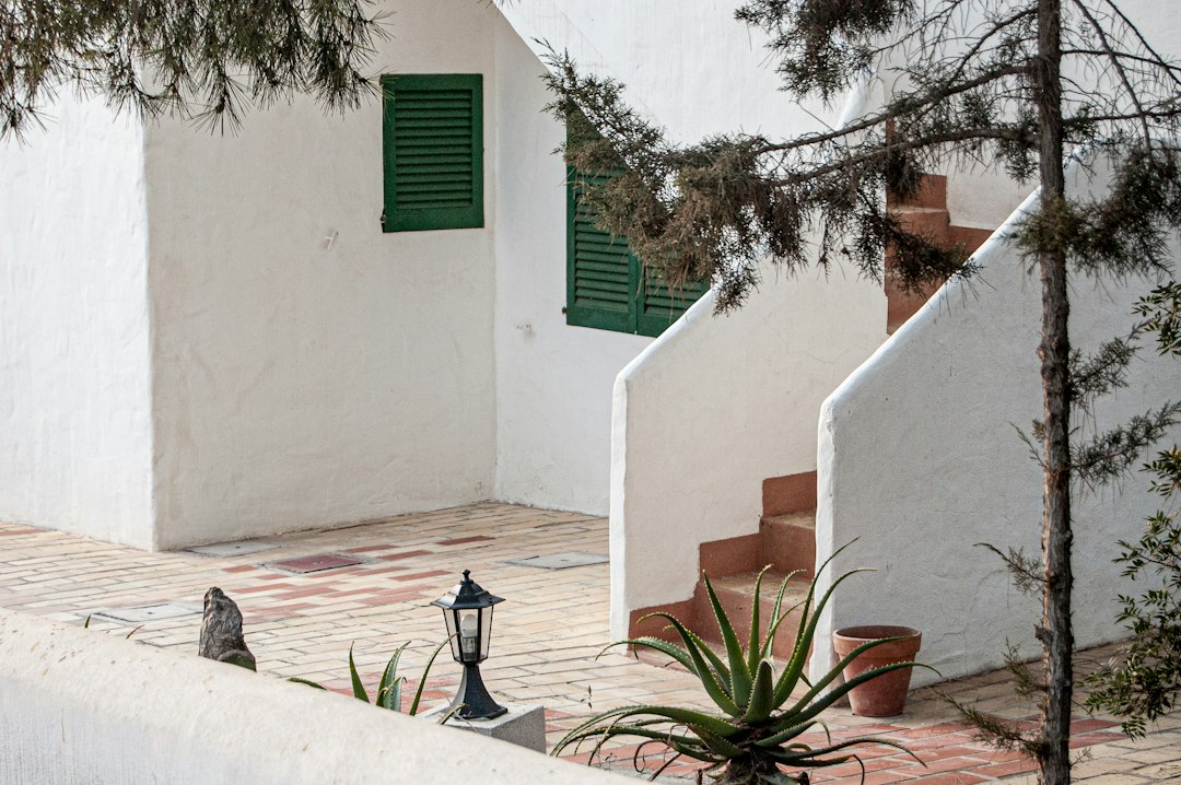 Atmospheric whitewashed Ibiza exterior with a chair; illustrative image, not actual student accommodation
